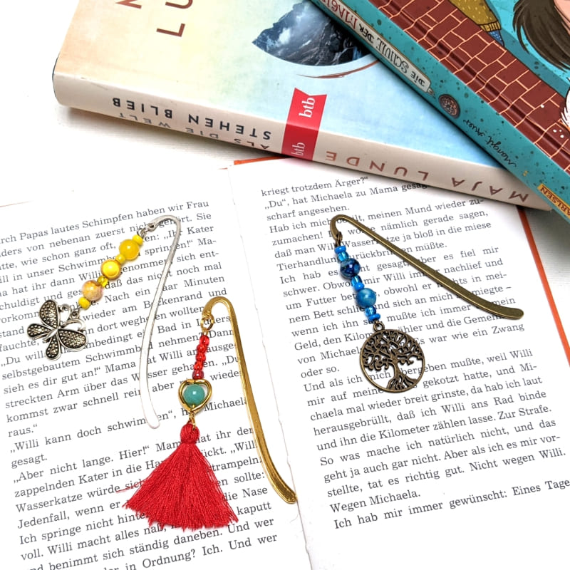 3 verschiedene Lesezeichen auf aufgeschlagener Buchseite 3 verschiedene Lesezeichen auf aufgeschlagener Buchseite